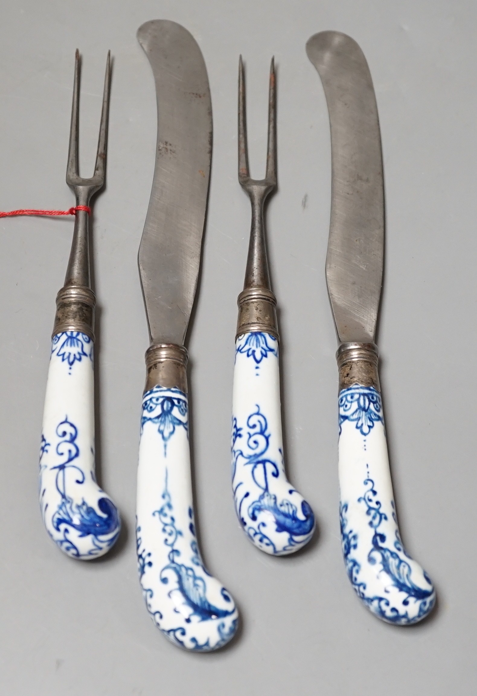 Two pairs of Bow blue and white pistol grip steel carving knives and forks, c.1755, longest night of 28cm